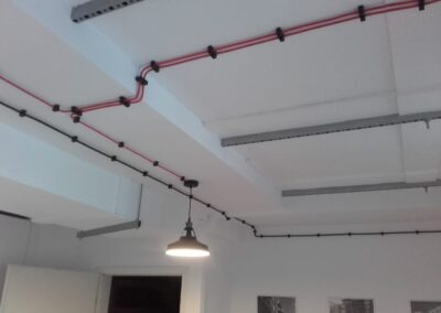 instalacja elektryczna natynkowa w biurze, czerwone i czarne kable