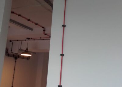 instalacja elektryczna natynkowa w biurze, czerwone i czarne kable