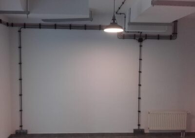 instalacja elektryczna natynkowa w biurze, czerwone i czarne kable, lampa w stylu loft